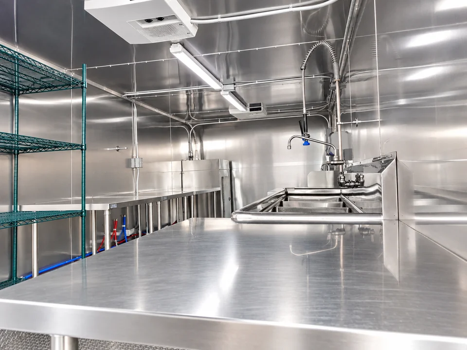 Stainless worktable and storage racks inside a dishwashing trailer